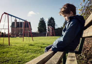 Upset problem child sitting on play park playground 